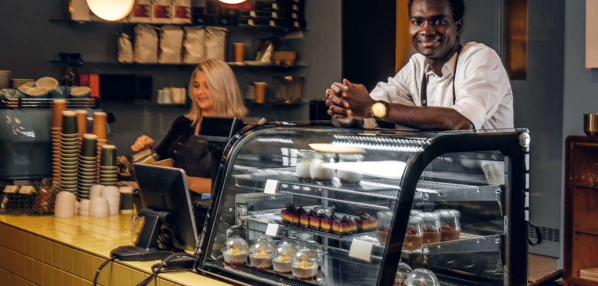 Two young multiracial baristas working at their trendy coffee shop.