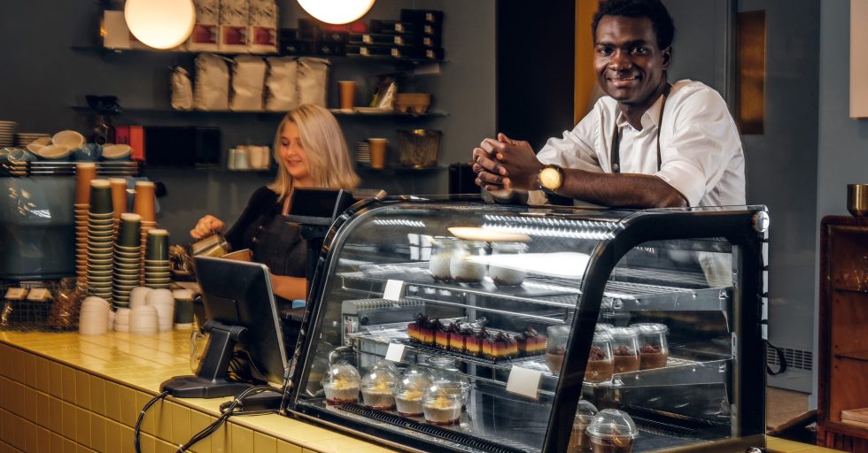 Two young multiracial baristas working at their trendy coffee shop.